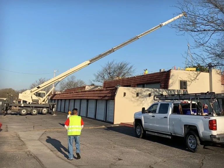 Crane lifting materials onto building roof.