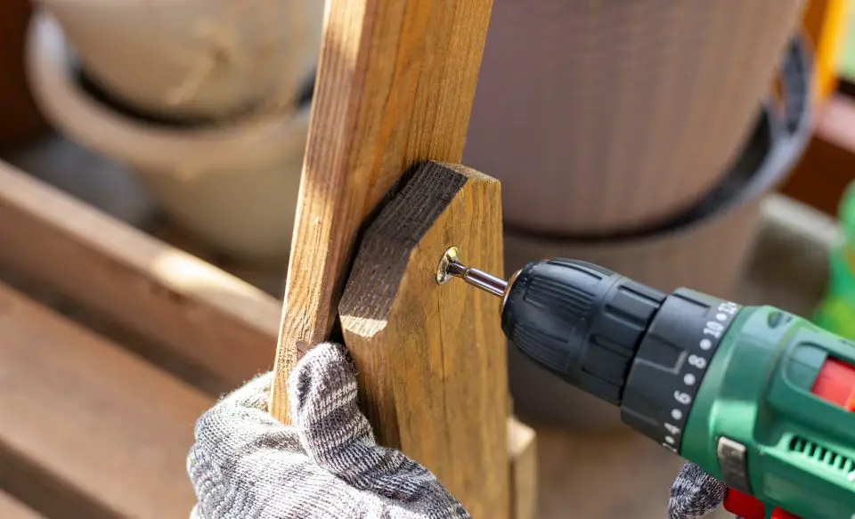 Person using drill on wooden board